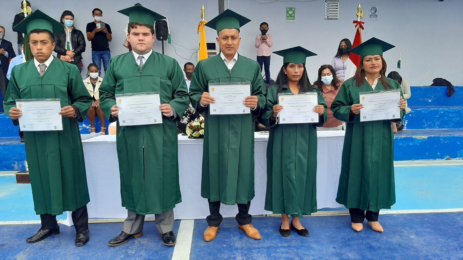 Estudiantes graduados del Colegio Pedro Vicente Maldonado sostienen sus diplomas durante la ceremonia de graduación.